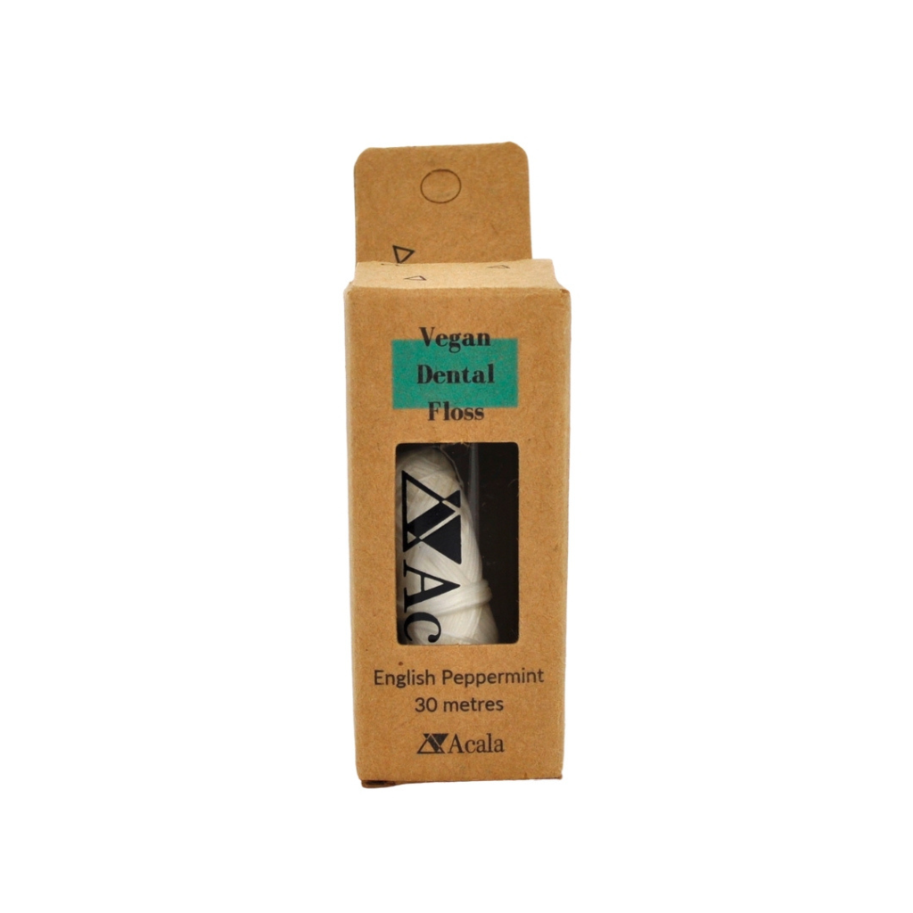 Brown recycled cardboard box with black text and turquoise accent. Containing a small glass container of Acala Vegan Dental Floss.