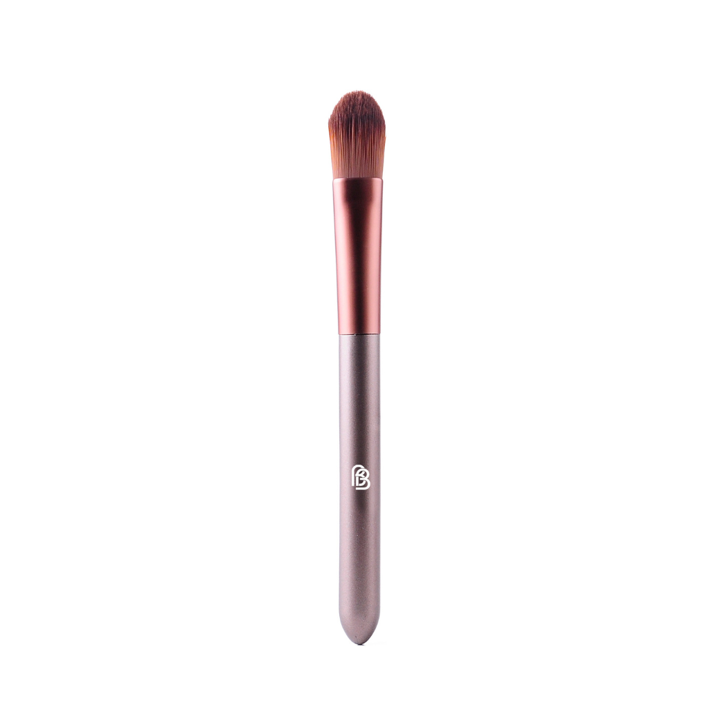purple/taupe matte plastic handled make up brush with rose gold brown metal section and synthetic bristles flat packed and rounded for the application of foundation and concealer