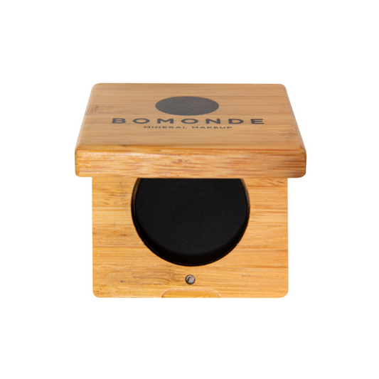 photo of bomonde mineral make up's eyeliner palette. the black eyeliner is pressed into a round pan and encased in a bamboo compact case.