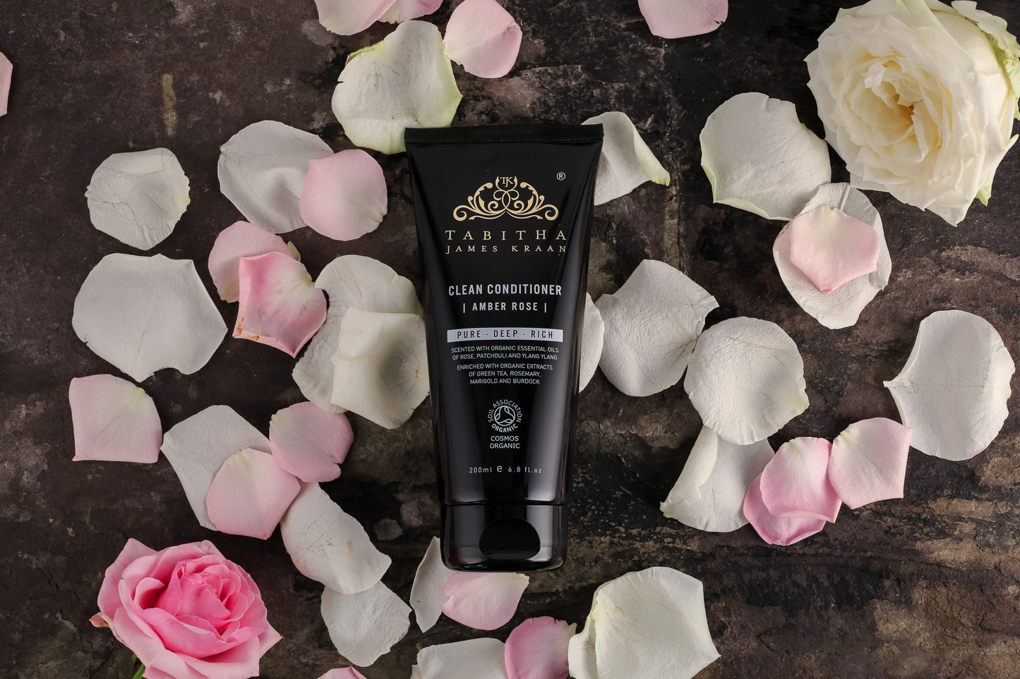 organic conditioner and hair mask black bottle on a bed of rose petals