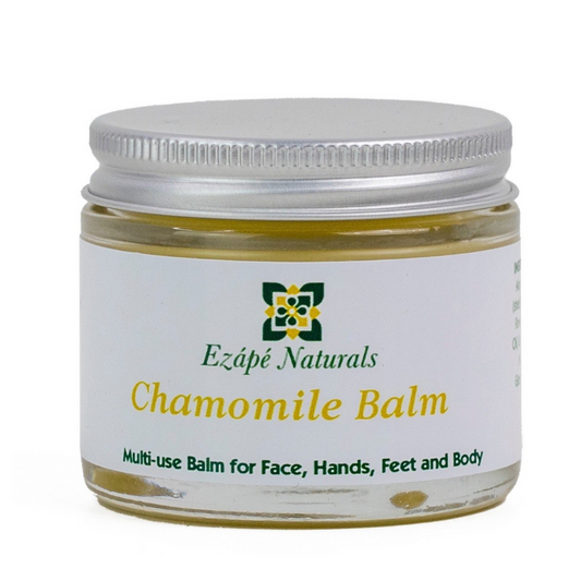 Large Chamomile balm which is handmade by ezape naturals is photographed on a white background. the multi use balm comes in a clear glass jar with a silver aluminium lid. the label is white and reads 'ezape naturals chamomile balm multi use balm for face, hands, feet and body’