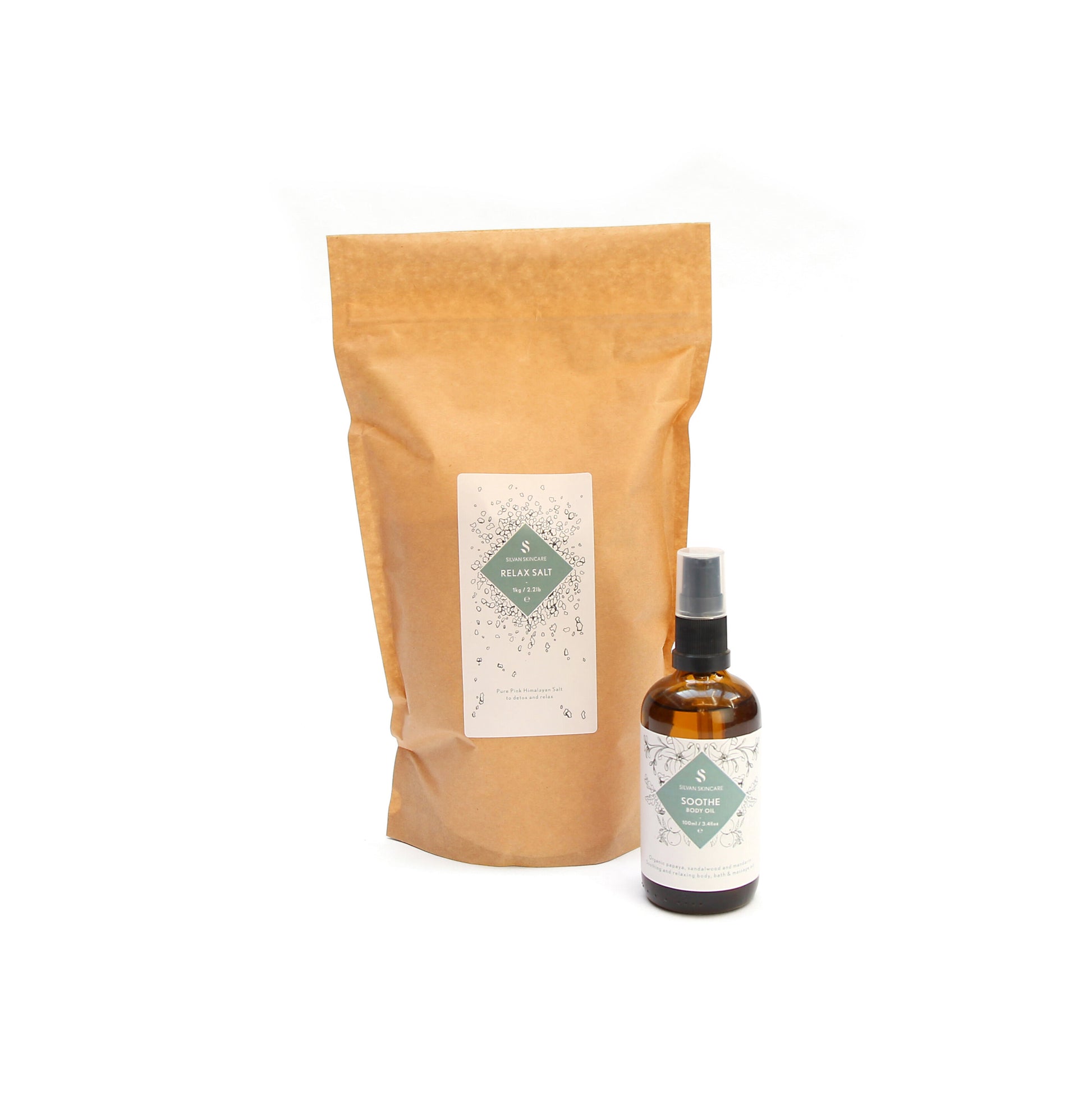 A brown bag of the relax salt and the Sooth Body oil placed in front of it, slightly to the left. Both items are have a white label and a teal diamond in the middle, listing the product and brand name.
