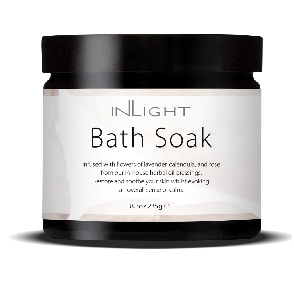 photo of inlight beauty bath soak in a black jar with black plastic lid and pinky white label which reads 'inlight bath soak infused with flowers of lavender, calendula and rose from our in-house herbal oil pressings. restore and soothe your skin whilst evoking an overall sense of calm'