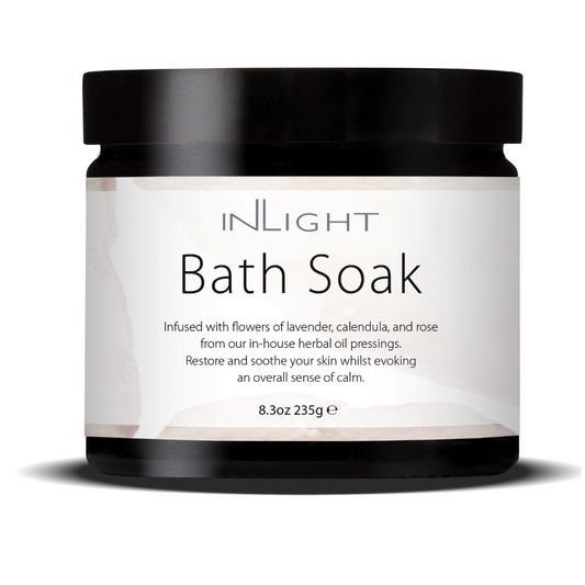 photo of inlight beauty bath soak in a black jar with black plastic lid and pinky white label which reads 'inlight bath soak infused with flowers of lavender, calendula and rose from our in-house herbal oil pressings. restore and soothe your skin whilst evoking an overall sense of calm'