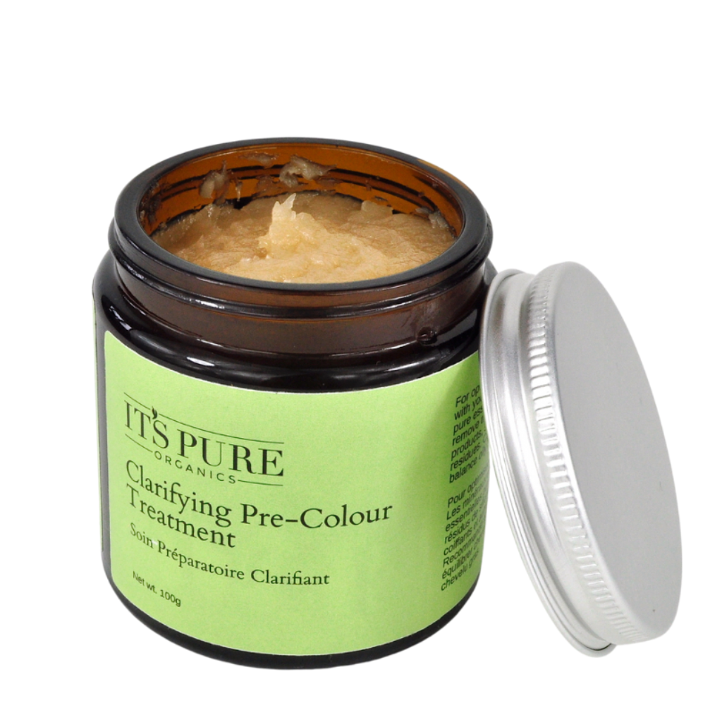 Open amber glass jar of the It’s Pure Clarifying Pre-Colour Treatment. The product label a light green with dark green text. The photo displays the product in the jar and the aluminium lid resting beside it.
