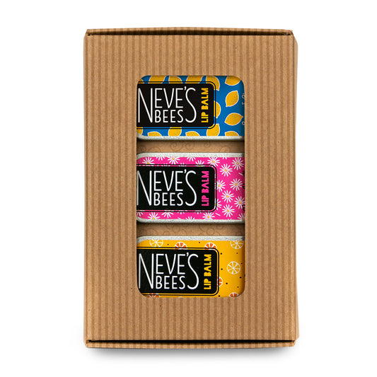 3 colourful rectangular lip balm tins in a brown cardboard window box. 