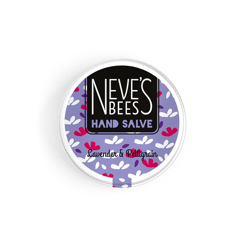 photo of neve's bees hand salve on a white background. the hand salve comes in an aluminium tin with a whitish purple label on it that reads 'neve's bees hand salve lavender and pettigrain' there are graphics of flower buds in the background of the label.