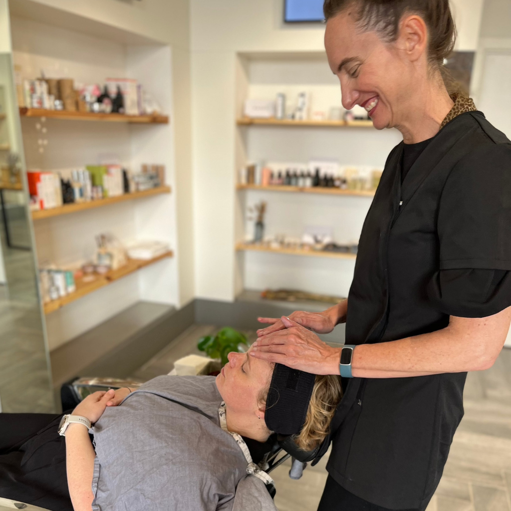 A serene moment captured as a customer receives an organic mini facial on the london shop floor, surrounded by shelves of natural skincare products