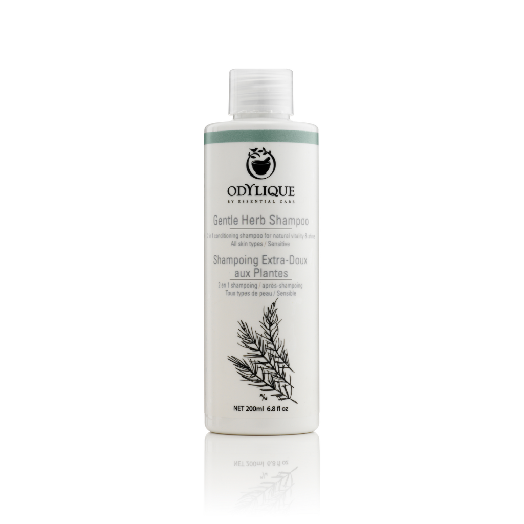 Odylique Gentle Herb Shampoo Bottle. White bottle with black and green text on white background.
