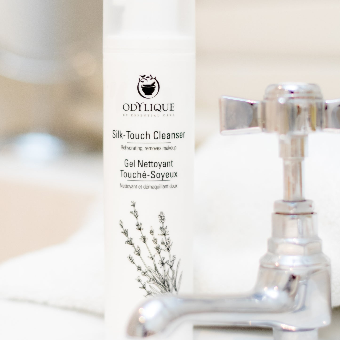 close up of silk touch cleanser sitting on the side of a sink next to a traditional style silver colour tap