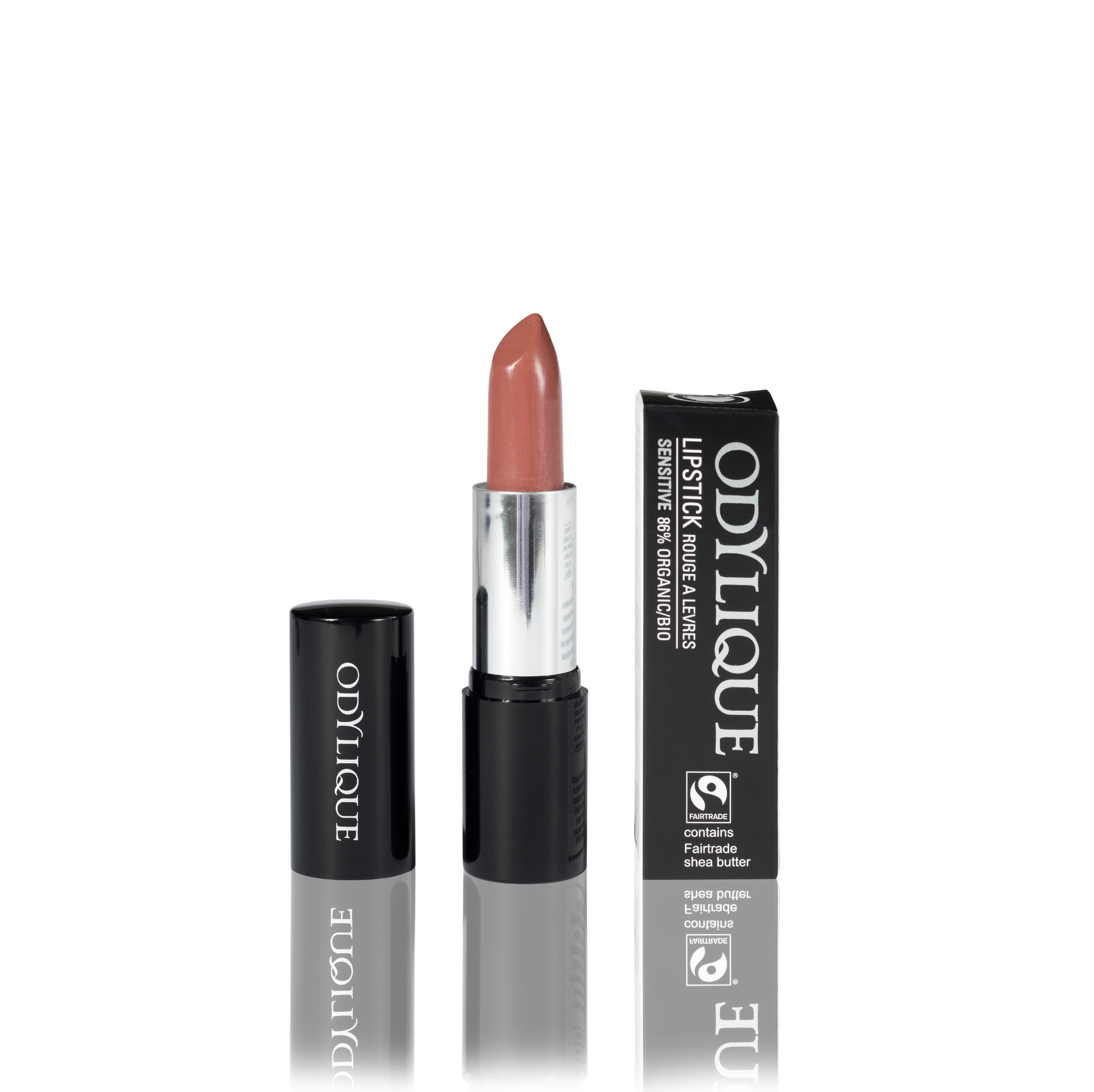 Odylique lipstick in Praline (nude natural brown) partially twisted up from its black tube, positioned next to its packaging on a reflective surface.