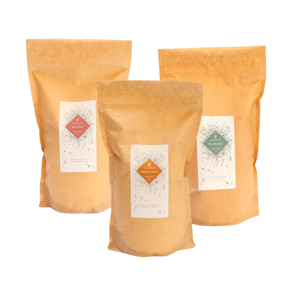 Three fully biodegradable bags made from kraft paper, cellulose and starch.bags. They each have white labels on them. The labels read Skin Salt, Muscle Salt and Relax Salt, each with distinct colour accents: pink, orange, and green, respectively.