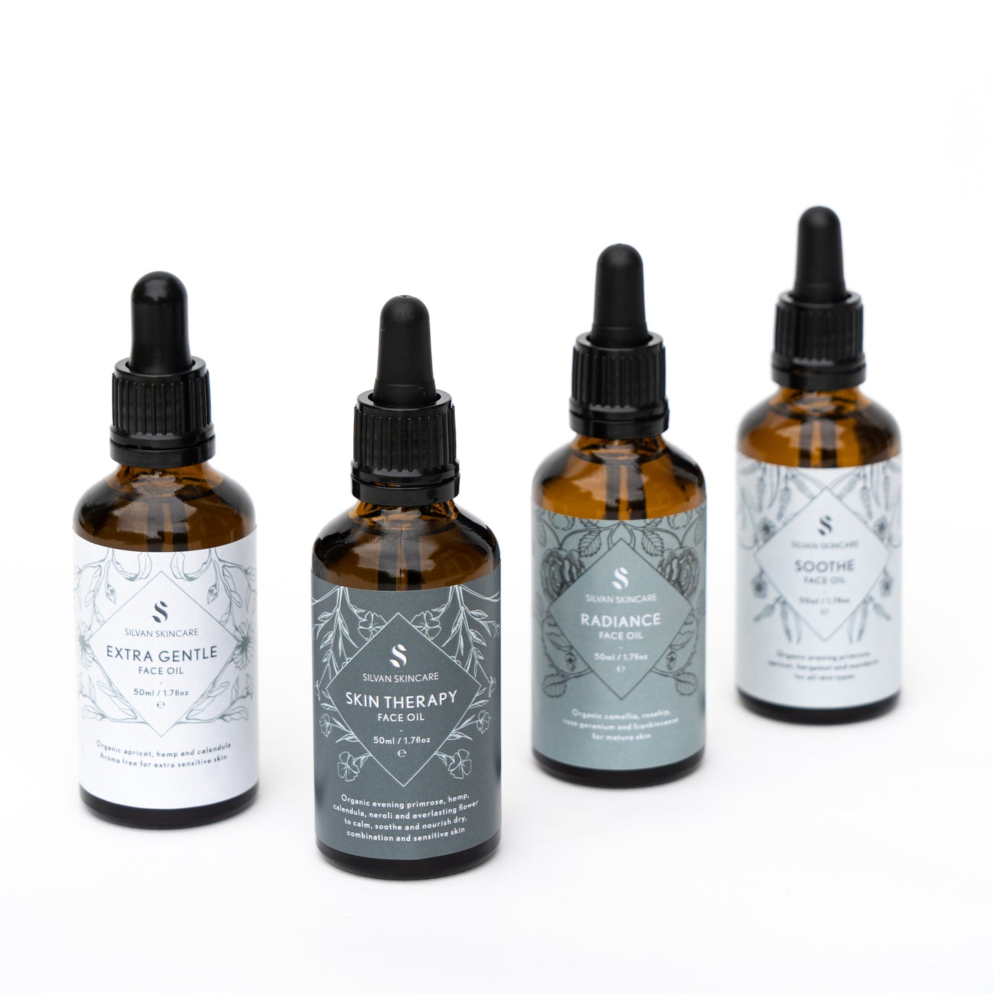set of 4 face oils in amber bottles with different gradient blue/grey labels