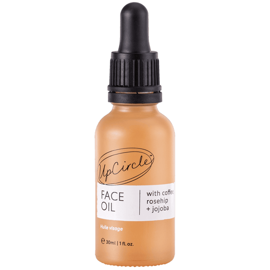 orange glass bottle of upcircle beauty's face oil with coffee, rosehip and jojoba with a black pipette lid