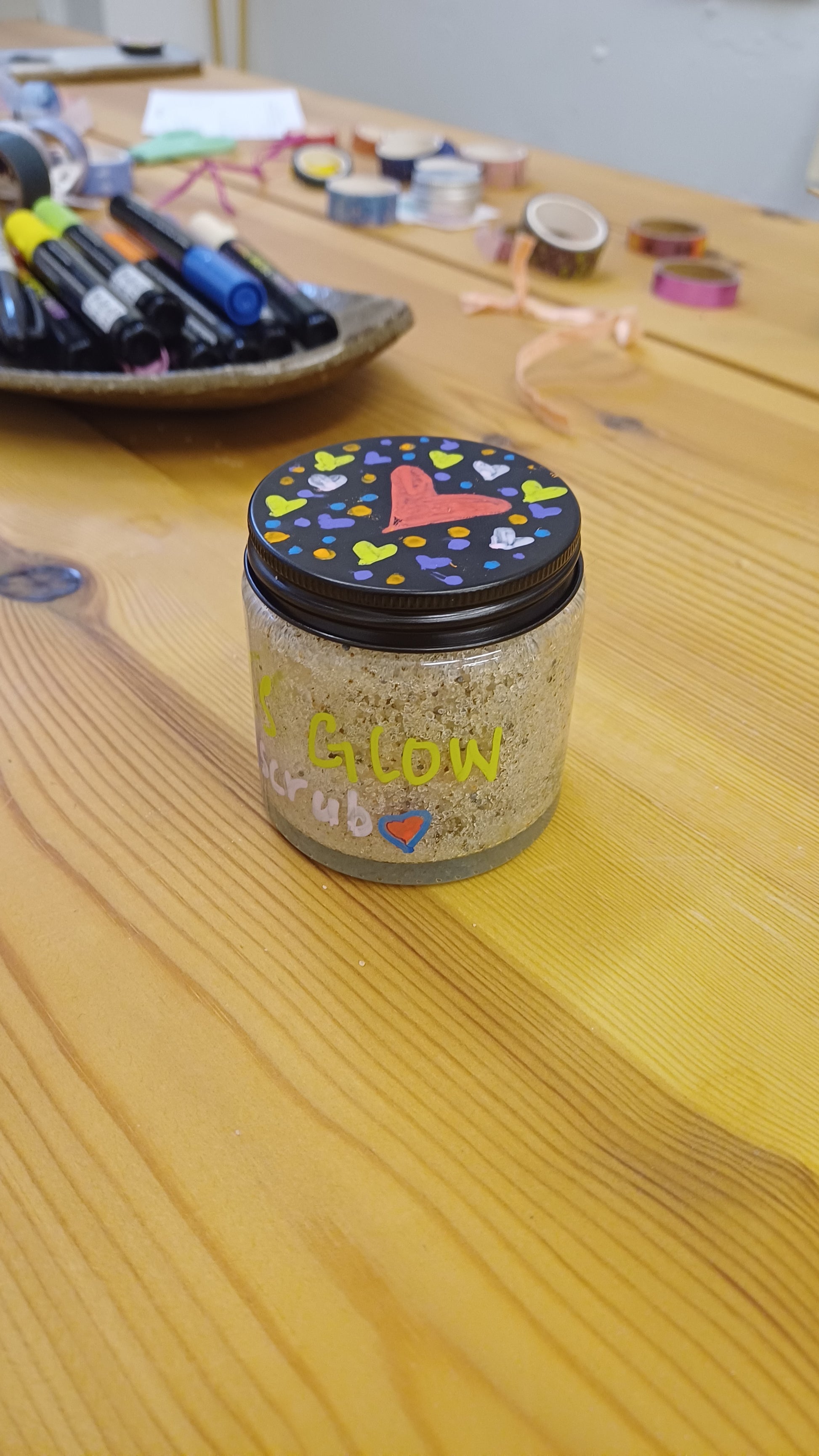glass jar with a black lid with heart drawings all over it
