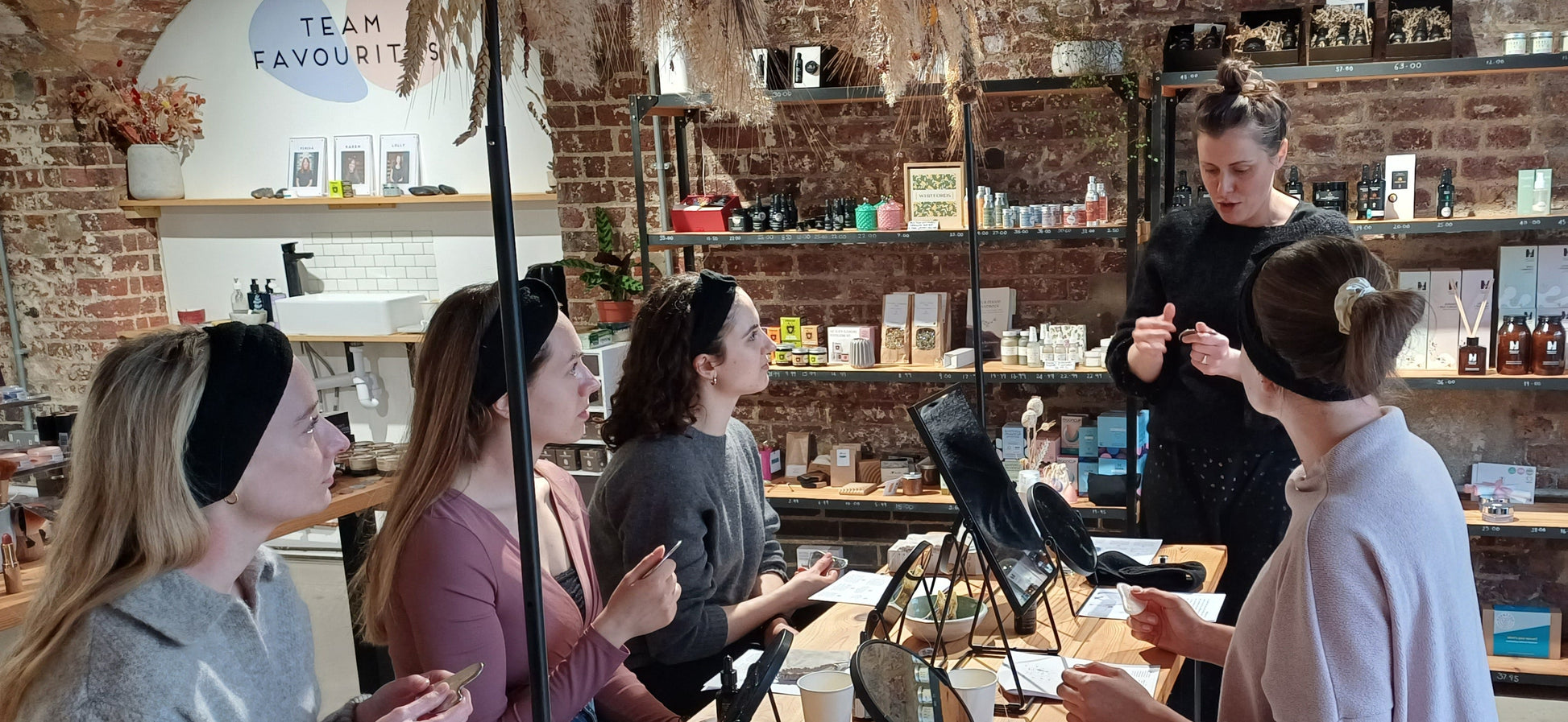 teacher showing a group of 4 women how to do facial gua sha massage