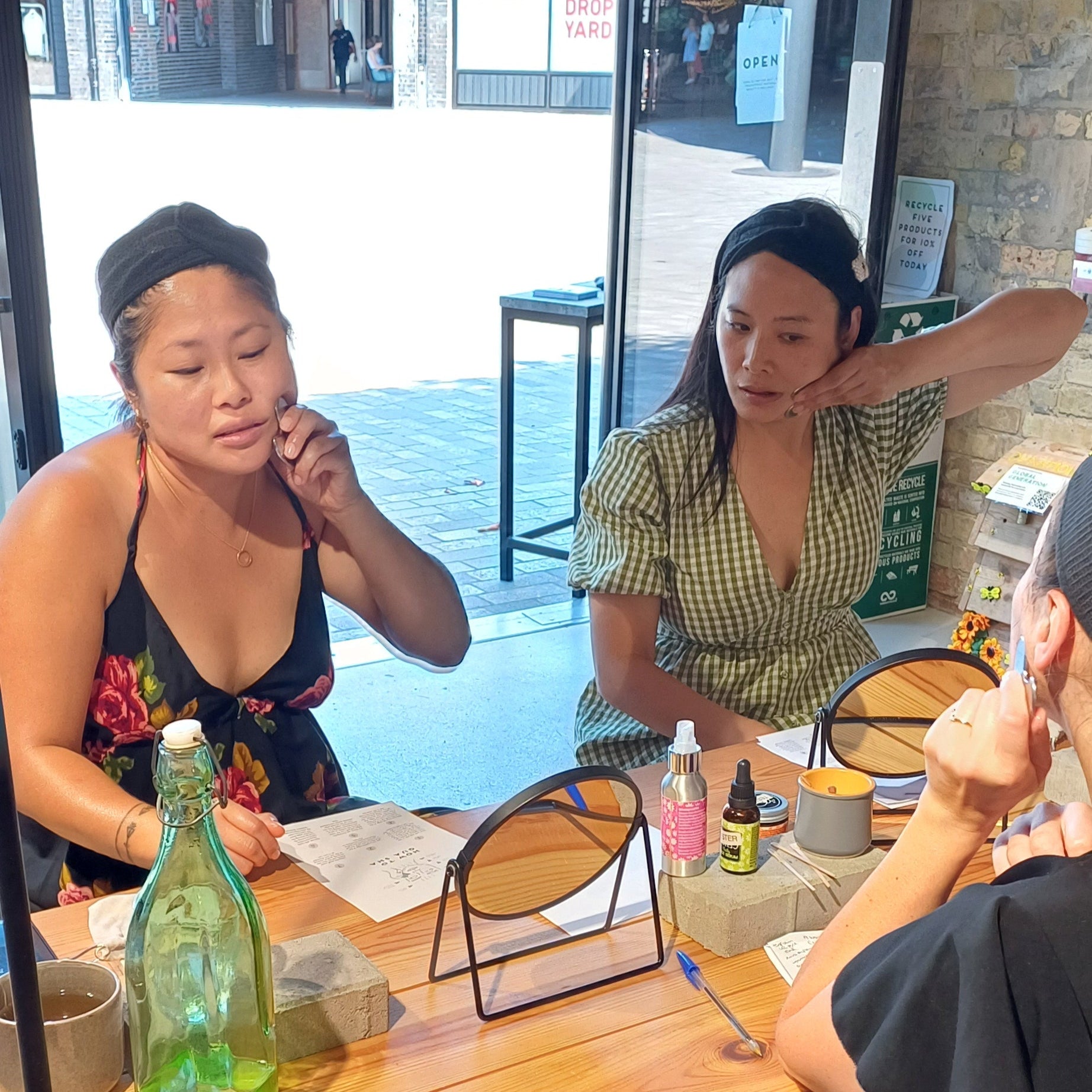 2 guests following along with the teacher at a gua sha facial massage class in london