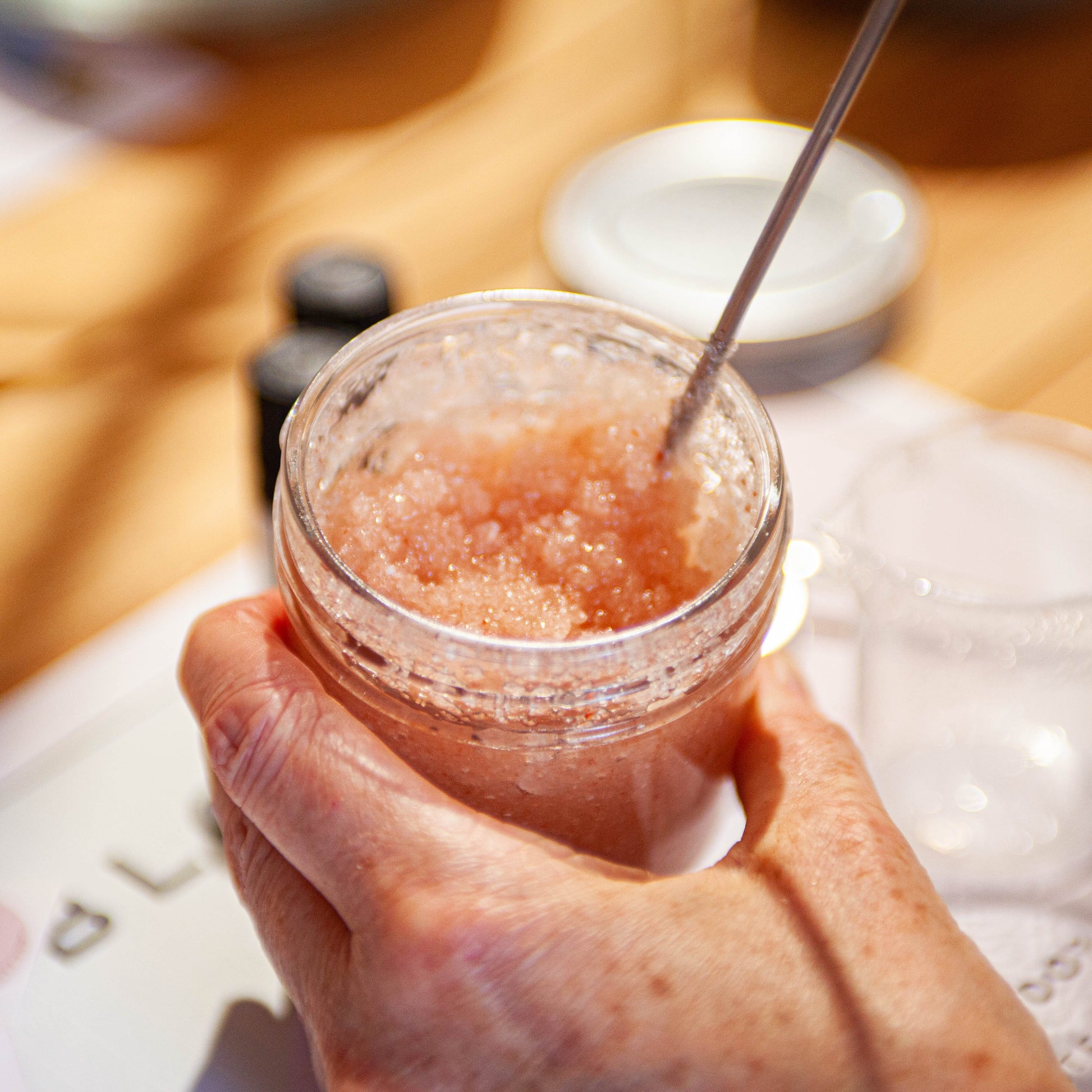 jar of body scrub being stirred