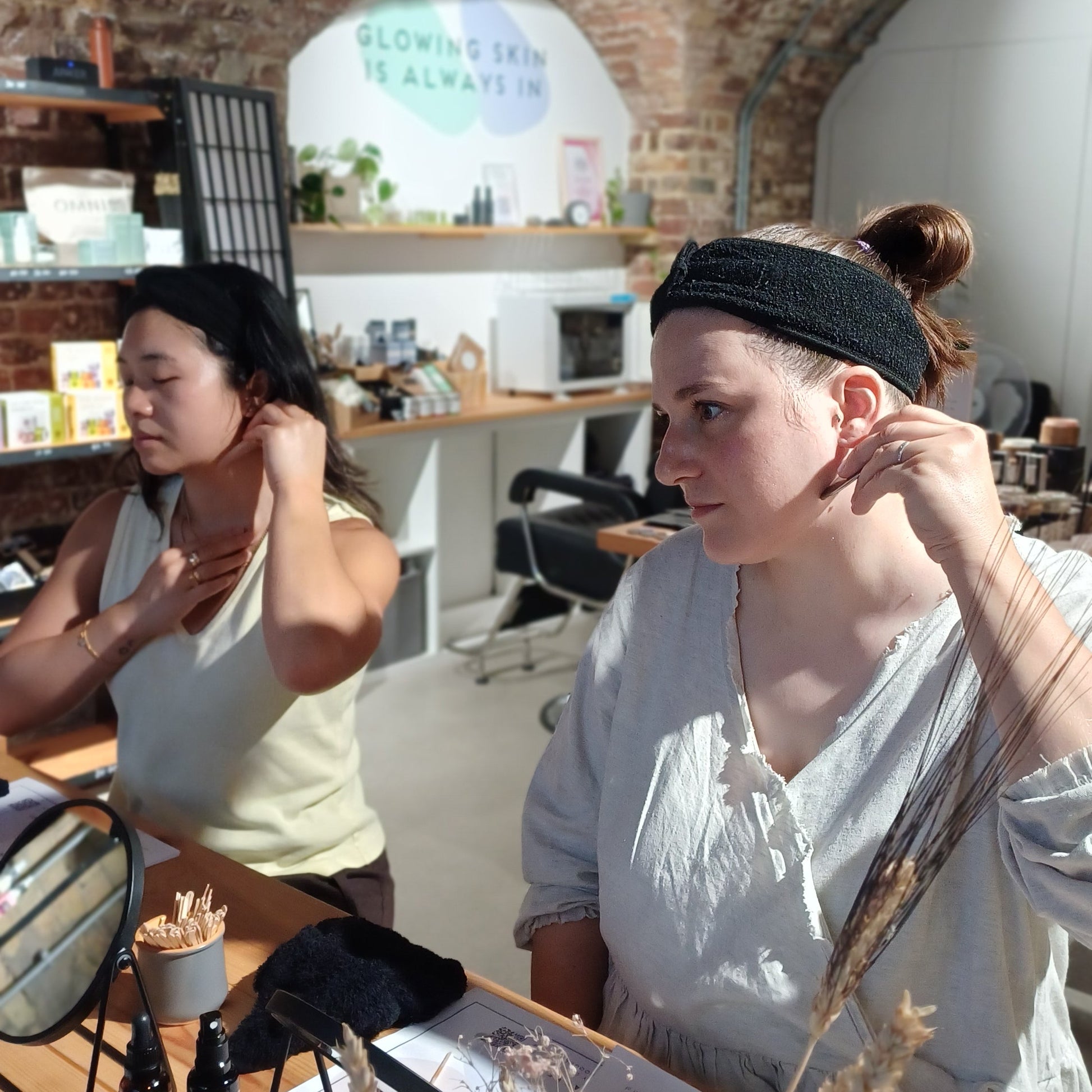 2 learners using a gua sha tool to massage their neck