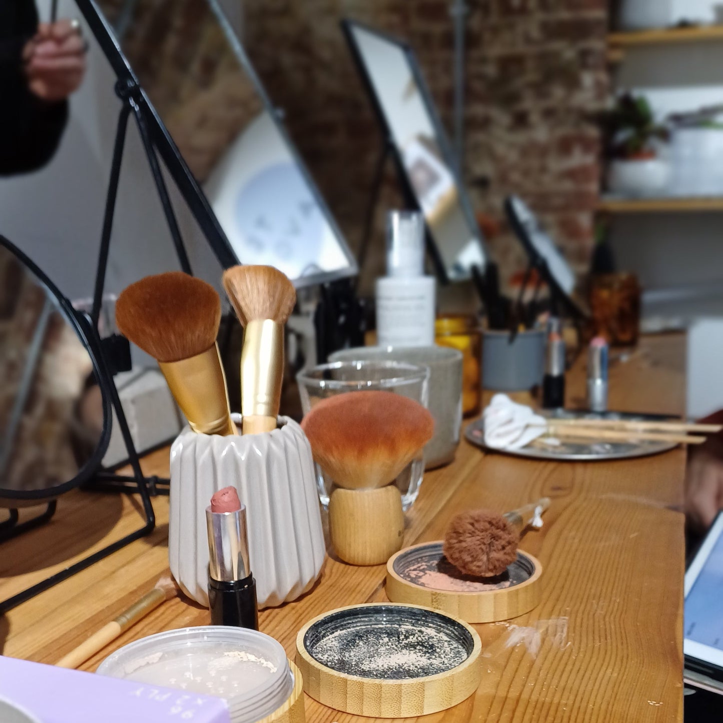 photo of natural, cruelty free make up and brushes on a wooden table with mirror