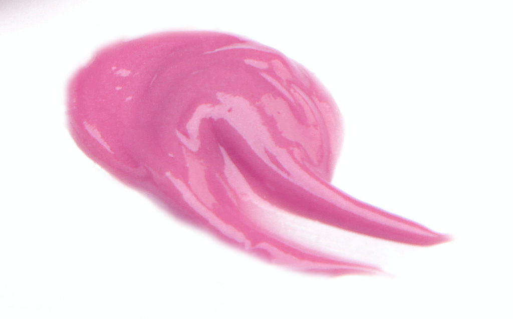 BareFaced Beauty Natural Mineral Lip Gloss in Sweetheart. Natural lip gloss. A dollop of gloss is spread on a white surface. The shade is a bright pink.