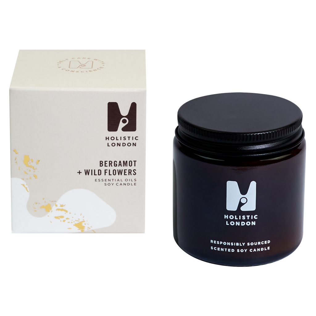 photograph of holistic london's bergamot + wildflowers 120g soy based candle on a white background. on the left side of the image is the light beige cardboard box with the holistic london logo on it. the label reads 'bergamot + wildflowers essential oils soy candle'. on the right side of the photo is the amber jar with a black aluminium lid which holds the candle. the glass is printed with the holistic london logo and says 'responsibly sourced scented soy candle'