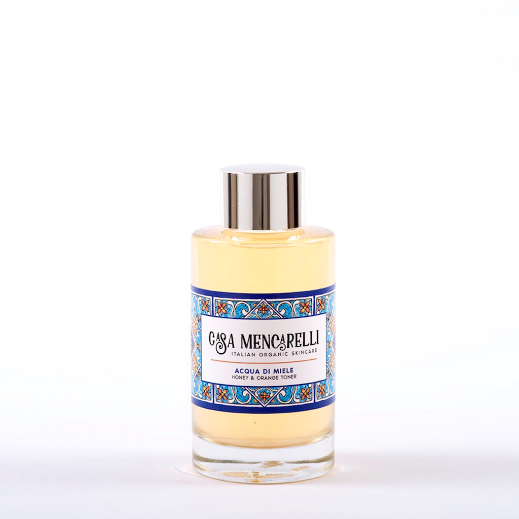 Casa Mencarelli Acqua di Miele Honey & Orange Toner. Natural toner. The toner is pictured in a glass bottle with an aluminium lid, decorated with a label with the signature tiling of Umbria in Italy.