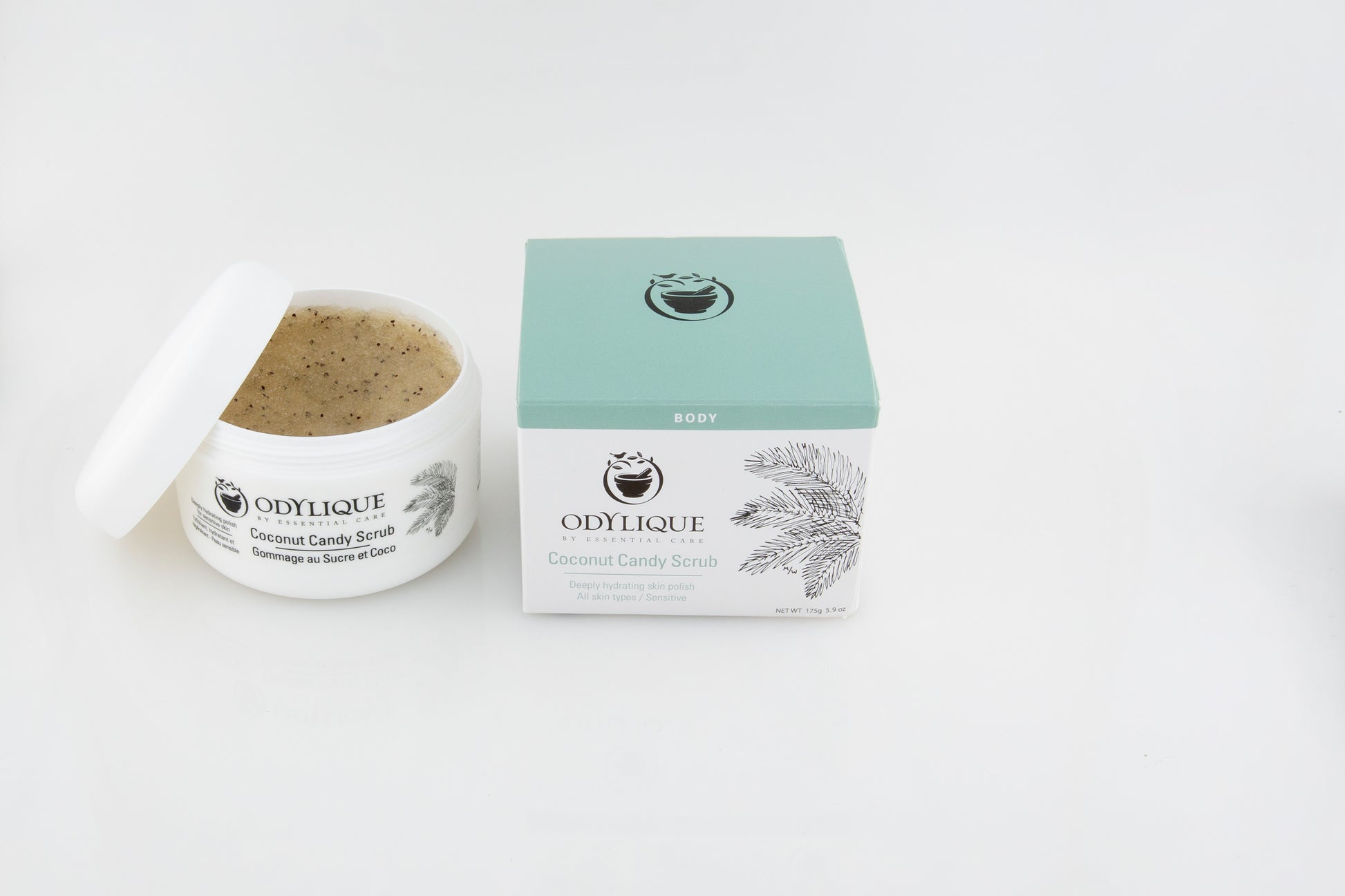 Odylique Coconut Candy Scrub, from above. The jar is open showing the scrub and the box is next to it. Vegan bodycare