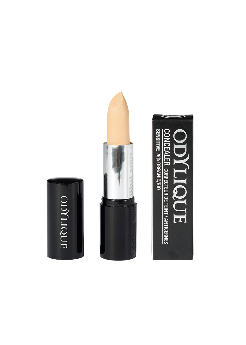 A single tube of the Odylique Fair concealer with the cap removed, revealing a light concealer shade, set against a plain white background.