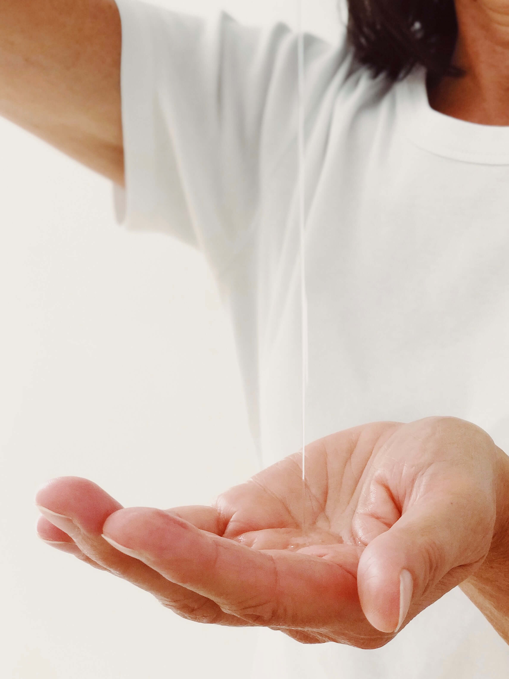 Haoma Organic Massage Oils. Organic body oils. The oil is being poured into a person's hand from out of the frame of the picture.