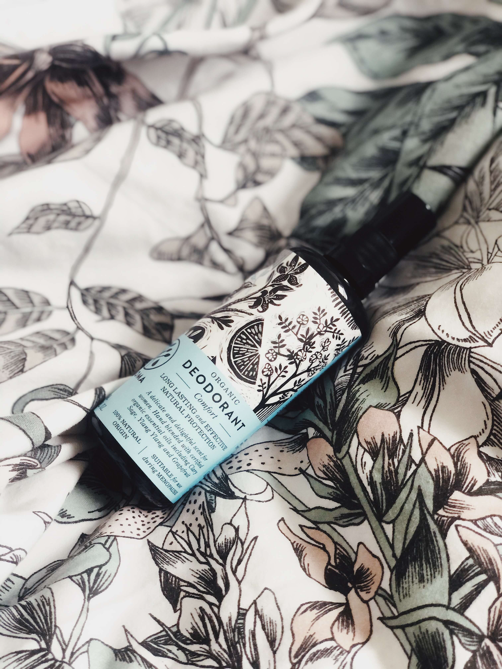 Haoma Organic Spray Deodorant. Deodorant for menopause without bicarbonate of soda. The Comfort deodorant is sitting on a black and white tablecloth.