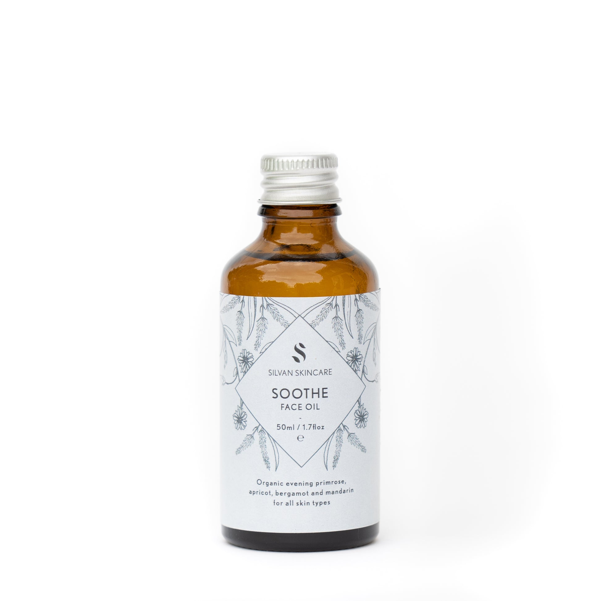 Silvan Skincare Soothe face oil  refill bottle. The facial oil is inside an amber glass bottle with a silver aluminium screw top. The bottle has a light blue label, black text listing the product and brand and black botanical illustrations.