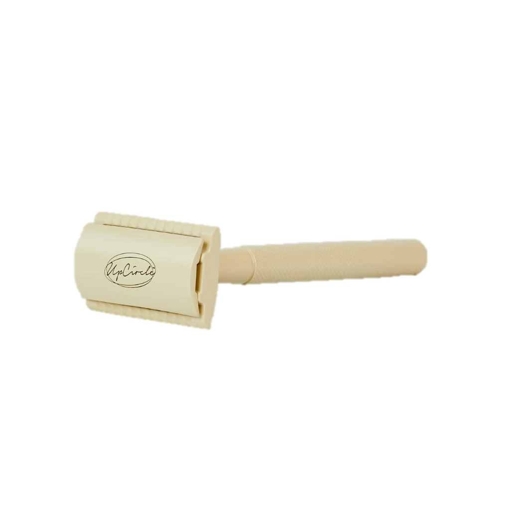 Upcircle safety razor on a white background. The razor is cream coloured and is branded with upcircle in black,