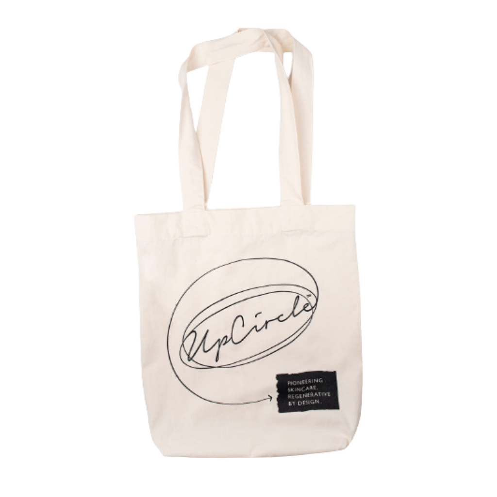 An image of the upcircle tote bag made from cotton and beige coloured. The brand name is printed in black.
