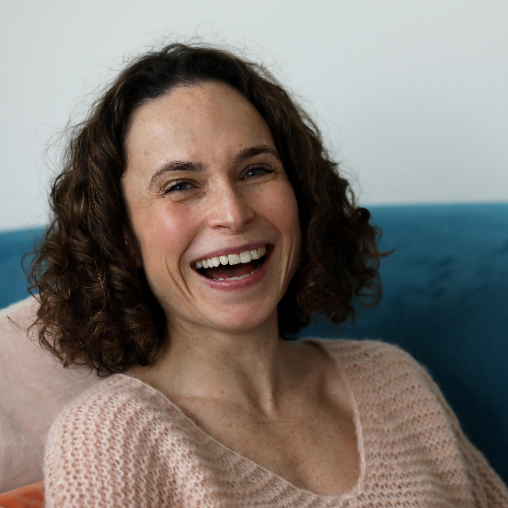 marishka dunlop life armour nutrition founder. She is sat on a dark blue chair and is pictured smiling widely.