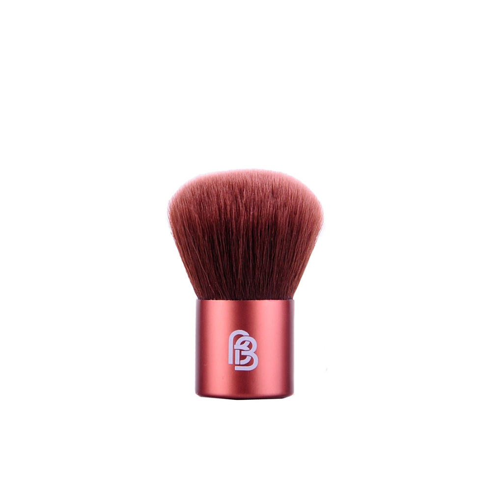 Barefaced beauty travel sized kabuki brush, with small orange metal handle and brown synthetic bristles 