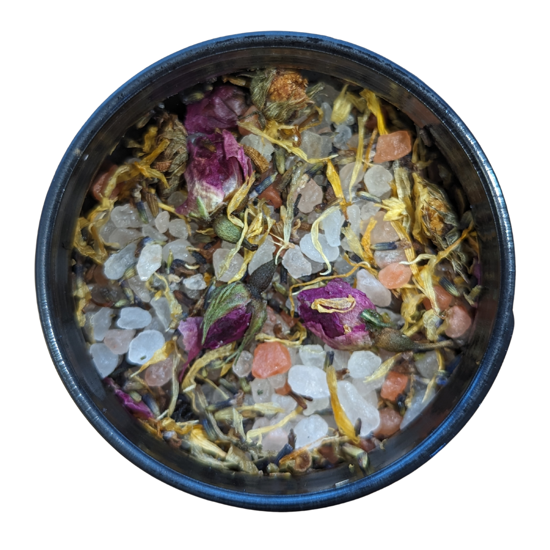 aerial view inside the inlight beauty bath salts where you can see grains of pink and white himlayan salt and dried herbs and flowers in a variety of colours including yellows, greens, pinky purples