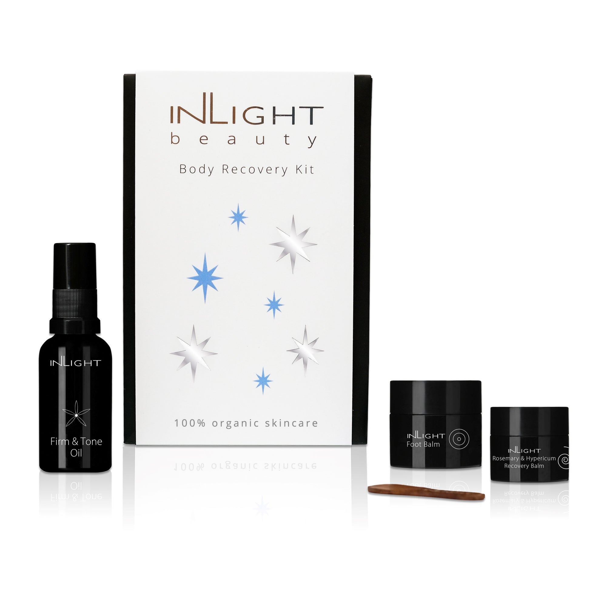 an organic skincare gift set for skin and mucsle recovery after exercise from inlight beauty. featuring 3 products. that are handmade in cornwall using organic ingredients. there's a firm and tone oil, a recovery balm and a foot balm, packaged in a black envelope box with a white branded sleeve featuring silver and blue stars