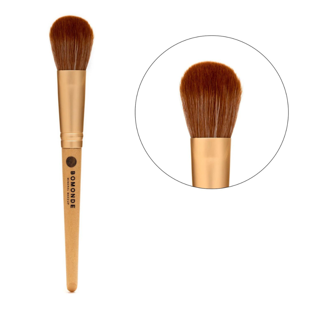 photo of bomonde's medium powder brush on a white background. on the left you can see the chestnut coloured bristles of the brush which are angled to add definition and contouring to your make up looks. there is a gold metal texture to help join the bristles to the yellow bamboo wooden handle which has the black bomonde logo printed on it. to the right of the image there is a close up of the cruelty free synthetic brush bristles in a circle