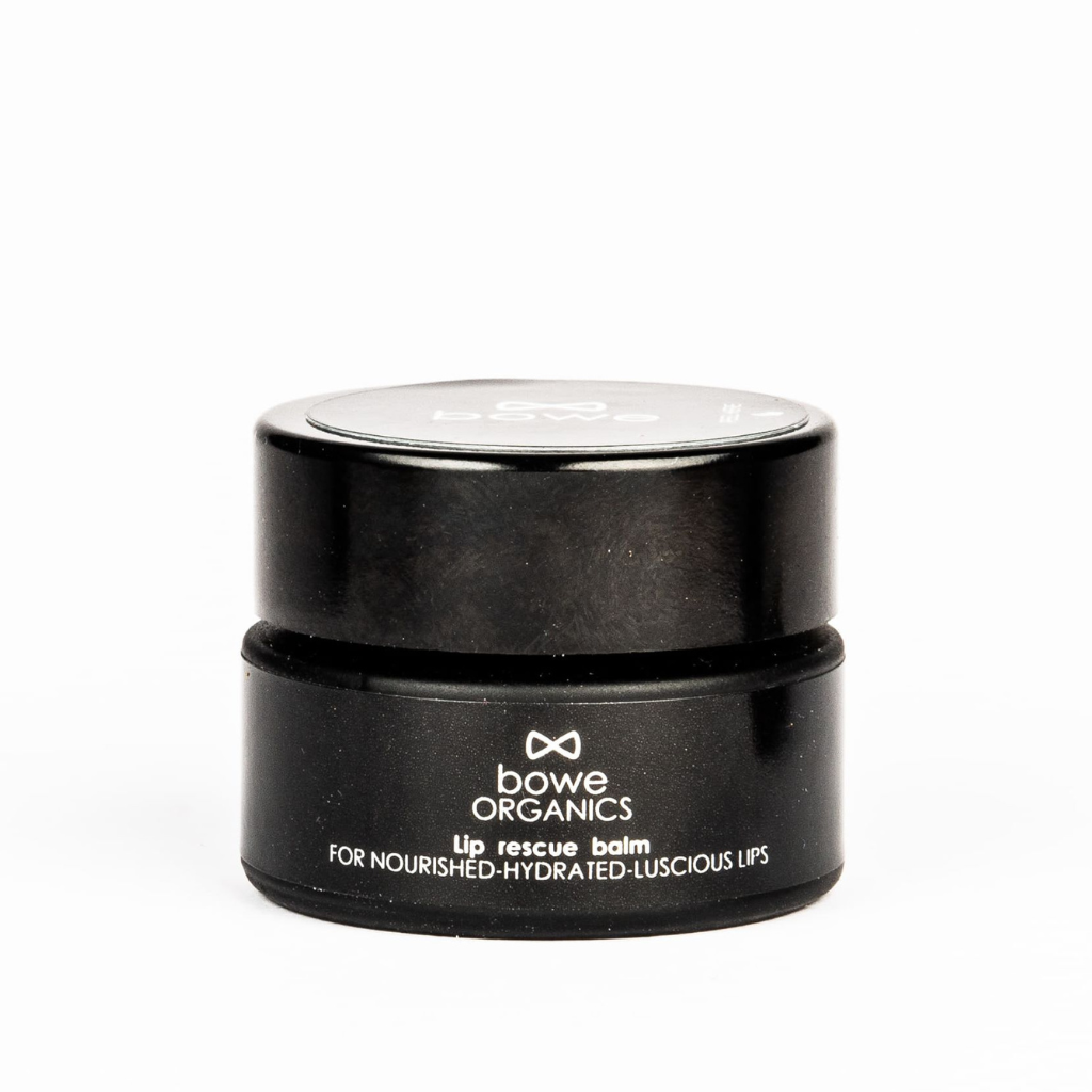 Bowe Organics lip rescue balm photographed on a white background. the vegan lip balm is in a matt black glass pot with a matching plastic lid. the label reads 'bowe organics lip rescue balm for nourished hydrated luscious lips’