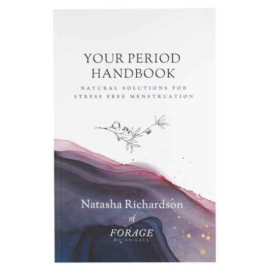 Image of the front cover of the Period Handbook, pictured on a white background. The book is white with deep purple to navy blue ombre abstract pattern with gold specks on the bottom half (reminiscent of a geological crystal formation). The top half of the book is white with black text and a botanical illustration in the middle.