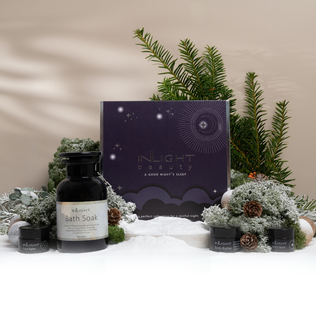 festive scene in the snow with festive foliage showcasing inlight beauty's good night's sleep gift box
