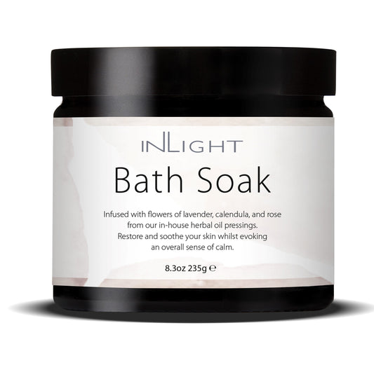 photo of inlight beauty bath soak in a black jar with black plastic lid and pinky white label which reads 'inlight bath soak infused with flowers of lavender, calendula and rose from our in-house herbal oil pressings. restore and soothe your skin whilst evoking an overall sense of calm'
