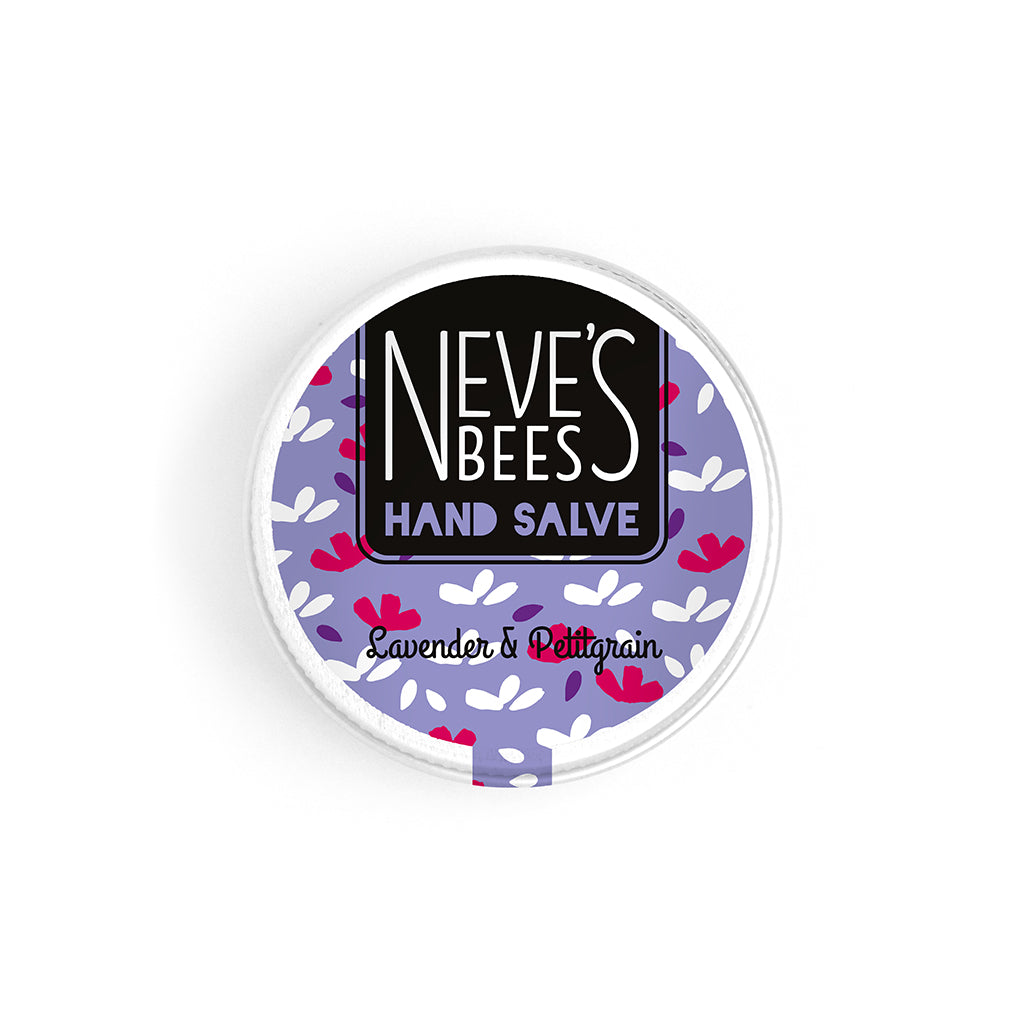 photo of neve's bees hand salve on a white background. the hand salve comes in an aluminium tin with a whitish purple label on it that reads 'neve's bees hand salve lavender and pettigrain' there are graphics of flower buds in the background of the label. 