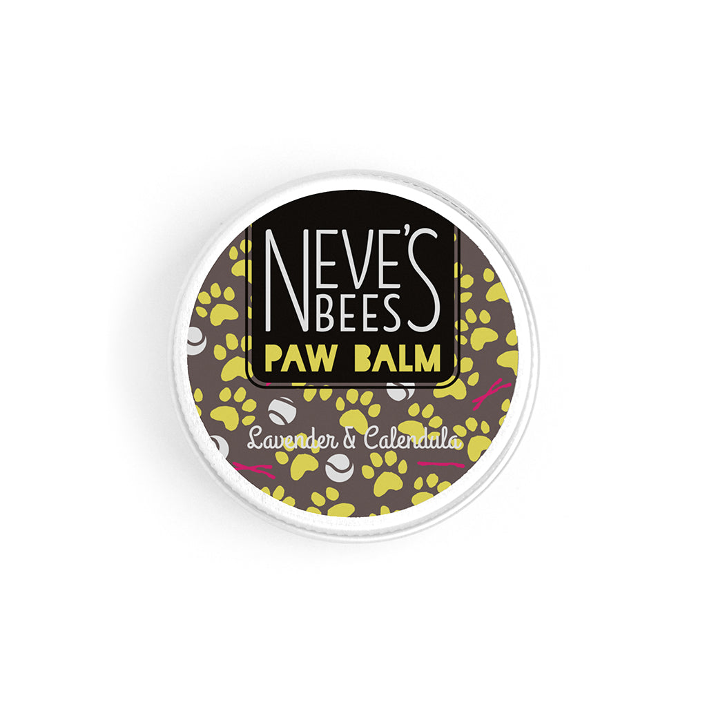 an aluminium tin of dog paw balm. You can see the white creamy texture of the salve. The tin lid has a grey, yellow and white sticker on it with the neve's bees logo and paw prints, sticks and balls on it