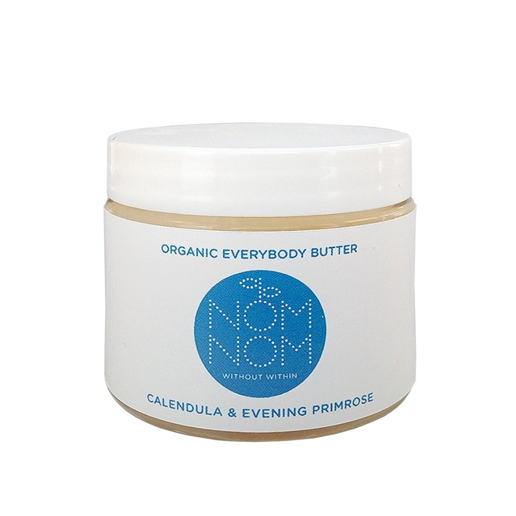 Nom Nom Organic everybody butter on a white background. the product comes in a clear glass jar with white plastic lid and white label with blue accents with Nom Nom name and logo.  