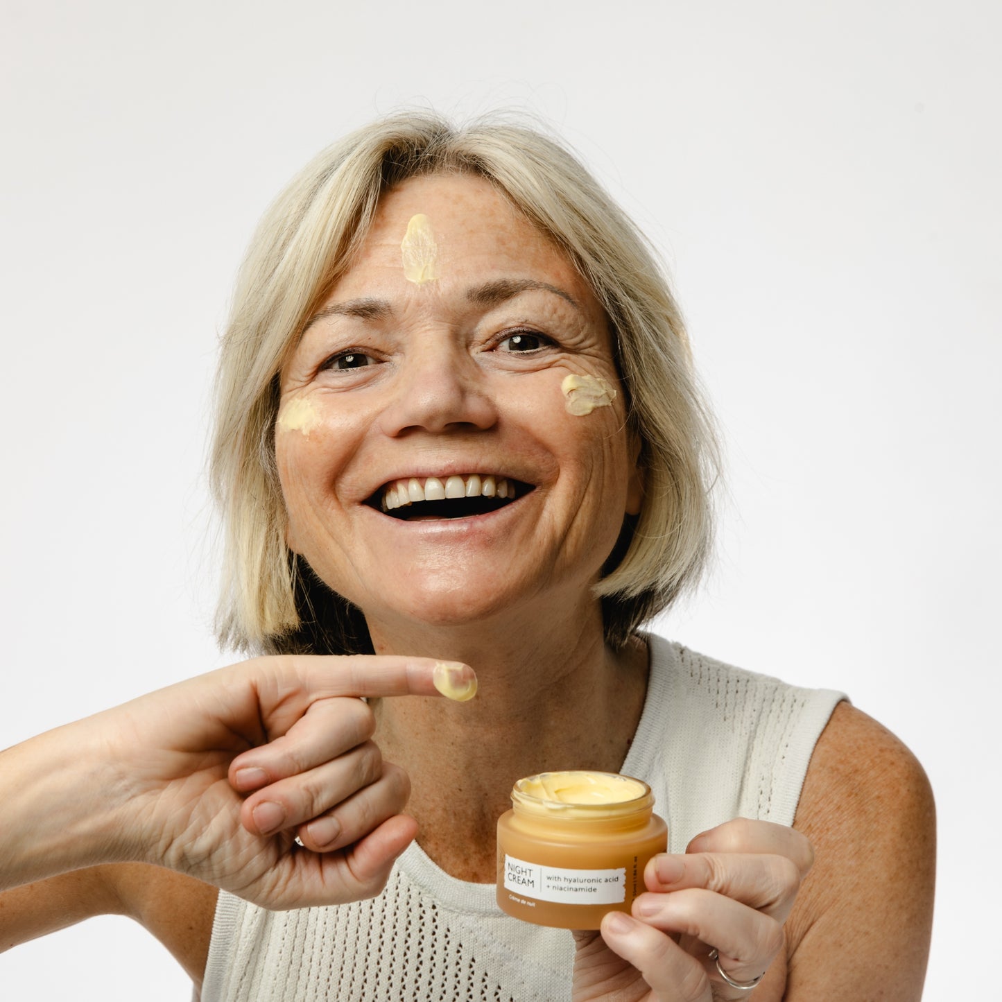 white woman applying the upcircle night cream to her skin