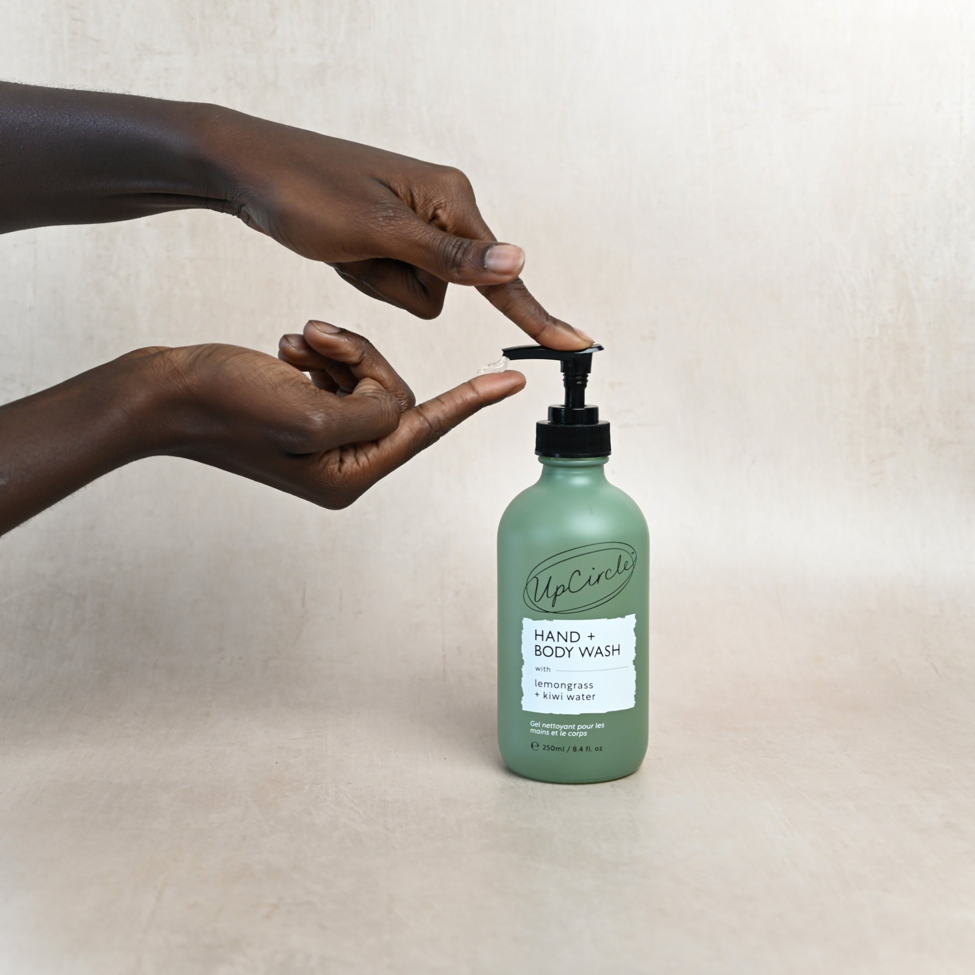 woman's hands dispensing upcircle hand a body wash onto her finger