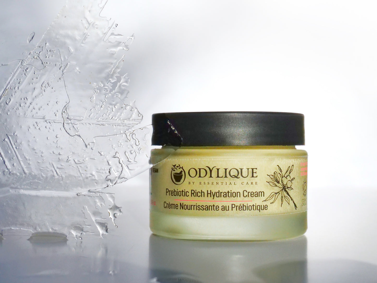 An image of the “Odylique Prebiotic Rich Hydration Cream” against a white/grey background on a reflective surface.