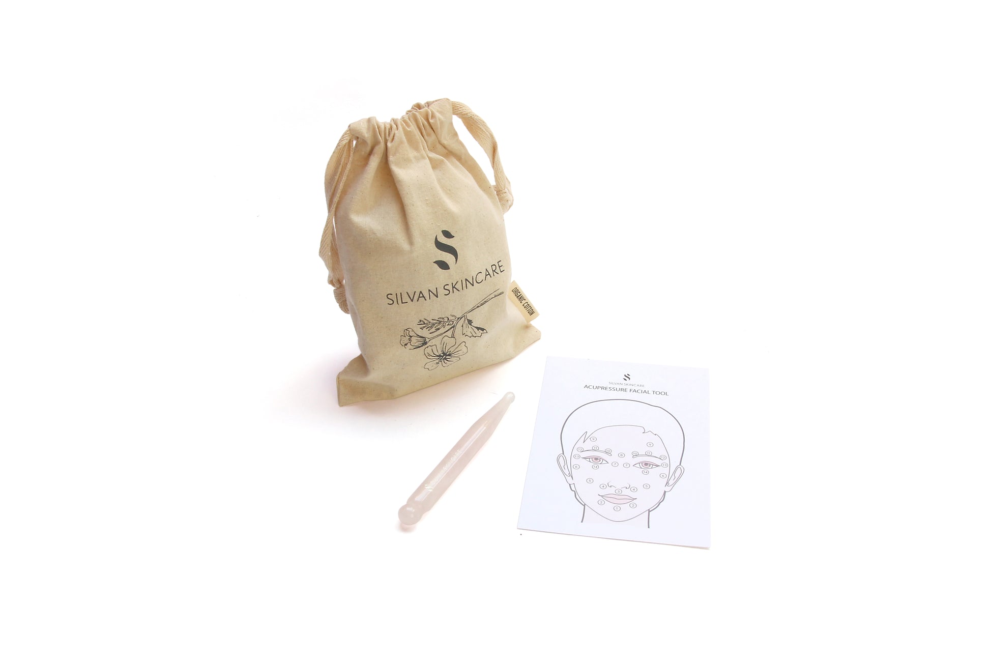 rose quartz reflexology tool sitting next to cotton cloth bag and acupressure points map/instruction card 